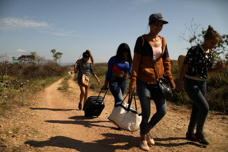 Venezuelan migrants walk along a trail into Brazil, in the border city of Pacaraima, Brazil, in April 2019. (CNS photo/Pilar Olivares, Reuters)
