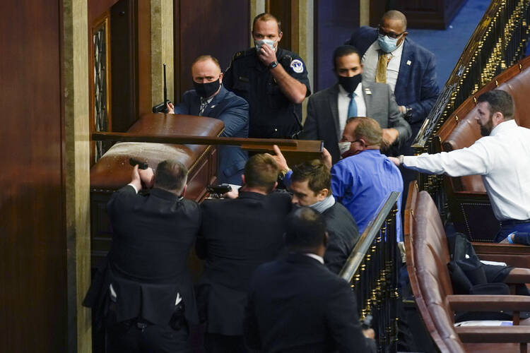 U.S. Capitol Police with guns drawn stand near a barricaded door as rioters try to break into the House Chamber at the U.S. Capitol on Jan. 6. (AP Photo/Andrew Harnik)