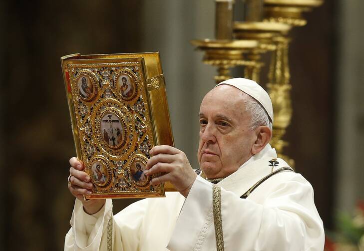Pope Francis raises the Book of the Gospels as he celebrates Mass marking the feast of the Epiphany in St. Peter's Basilica at the Vatican