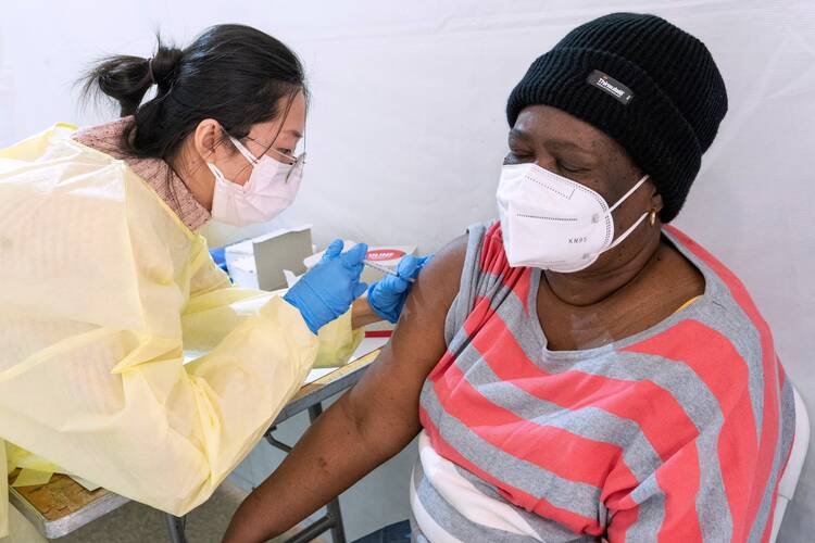 Registered nurse Shyun Lin gives Alda Maxis, 70, the first dose of the Covid-19 vaccine in Brooklyn, N.Y., on Jan. 23, 2021. (CNS photo/Mary Altaffer, Pool via Reuters)