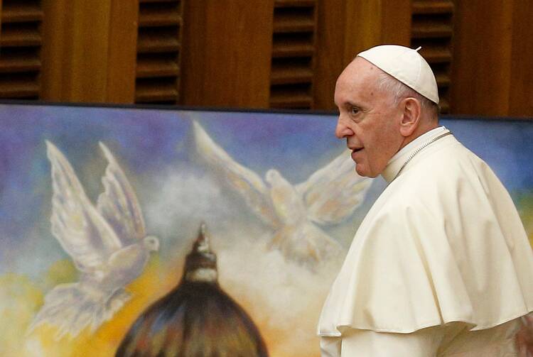 Pope Francis walks past artwork showing the dome of St. Peter's Basilica and two doves during his general audience at the Vatican in this Aug. 8, 2018, file photo. (CNS photo/Paul Haring)