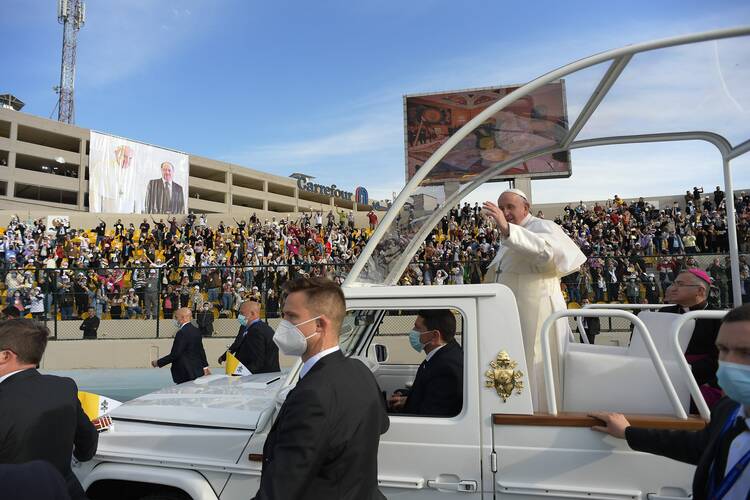 Pope Francis greets the crowd as he arrives to celebrate Mass at Franso Hariri Stadium in Erbil, Iraq, on March 7. (CNS photo/Vatican Media)
