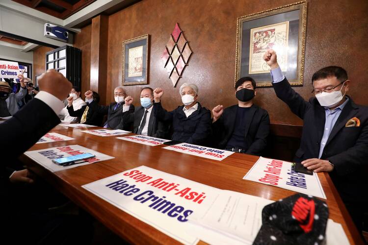 Members of the Atlanta Korean American Committee against Asian Hate Crime raise their fists as they meet at a Korean restaurant in Duluth, Ga., on March 18, 2021, after the fatal shootings at at three Atlanta-area spas. (USA/Dustin Chambers, Reuters)