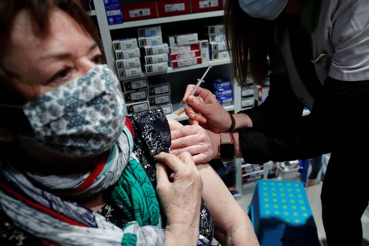 A pharmacist administers the AstraZeneca Covid-19 vaccine to a patient in a pharmacy in Paris on March 19, 2021. (CNS photo/Benoit Tessier, Reuters)