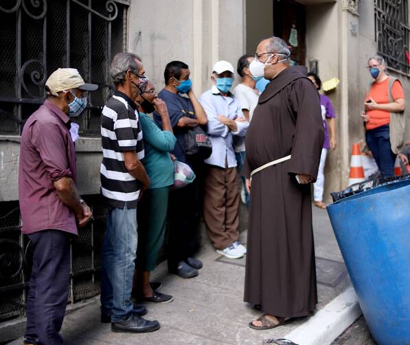 José Francisco, O.F.M., greets the queue in front of a Sefra food distribution site in São Paulo. Photo courtesy of Equipe de Comunicação Sefras.