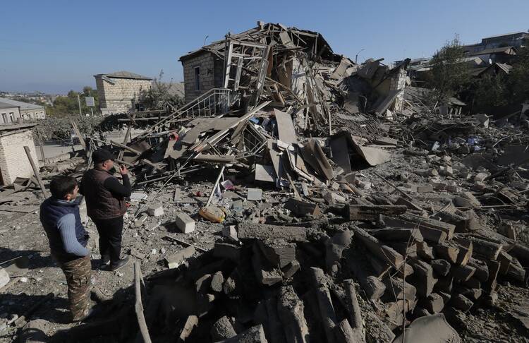 The genocide of Christians in the Middle East continues to this day, as seen in Azerbaijan’s occupation of Nagorno-Karabakh, a disputed region with an Armenian majority. In this photo, men look at the ruins of a house in the city of Stepanakert on Oct. 17, 2020. (CNS photo/Reuters)