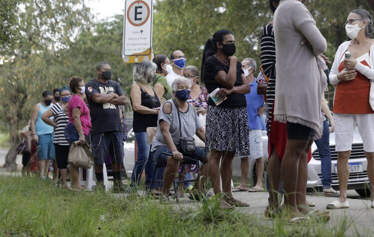 People wait outside a vaccination station to receive a dose of the Sinovac CoronaVac COVID-19 vaccine in Belford Roxo, Brazil, March 31, 2021, during a vaccination day for citizens 71 and older. (CNS photo/Ricardo Moraes, Reuters)