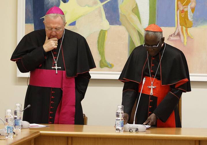 Archbishop Arthur Roche, then secretary of the congregation, left, and Cardinal Robert Sarah, then prefect of the Congregation for Divine Worship and the Sacraments, pray with U.S. bishops at the start of a meeting at the congregation at the Vatican on Jan. 14, 2020. (CNS photo/Paul Haring) 
