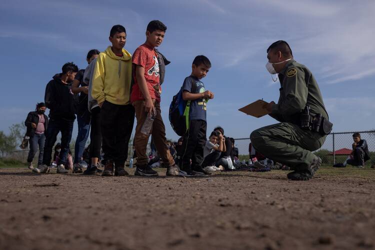Anderson, a 6-year-old unaccompanied minor from El Salvador, stands in line with other asylum-seeking children in La Joya, Texas, on May 14, as they identify themselves to a Border Patrol agent after crossing the Rio Grande from Mexico. (CNS photo/Adrees Latif, Reuters)