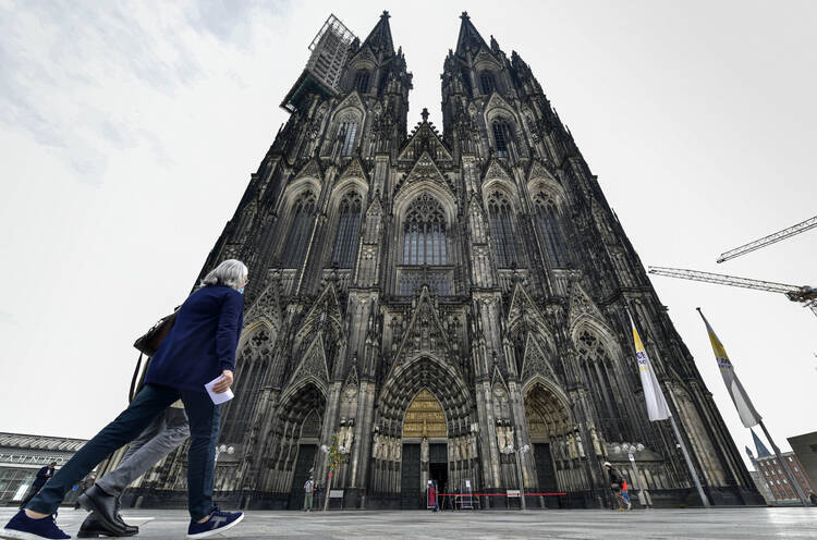 In this Sunday, May 3, 2020 file photo people arrive for a church service at Germany's famous Cologne Cathedral in Cologne, Germany. (AP Photo/Martin Meissner, file)
