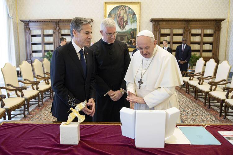 Pope Francis exchanges gifts with U.S. Secretary of State Antony Blinken during an audience at the Vatican June 28, 2021. Blinken presented a sculpture to the pope of a dove holding an olive branch. (CNS photo/Vatican Media)