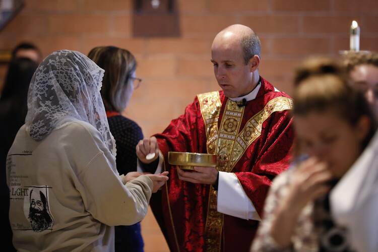 Students receive Communion from Father Matthew Lowry during daily Mass at Holy Trinity Newman Center on the campus of Northern Arizona State University in Flagstaff on Nov. 25, 2019. (CNS file photo/Nancy Wiechec) 