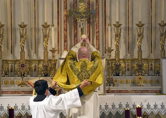 Father Stephen Saffron, parish administrator, elevates the Eucharist during a traditional Latin Mass July 18, 2021, at St. Josaphat Church in the Queens borough of New York City. (CNS photo/Gregory A. Shemitz)