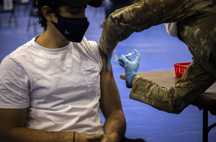 A health care worker administers the Pfizer Covid-19 vaccine to a Marymount University student on the Catholic university's Arlington, Va., campus on April 21, 2021. (CNS photo/Chaz Muth)