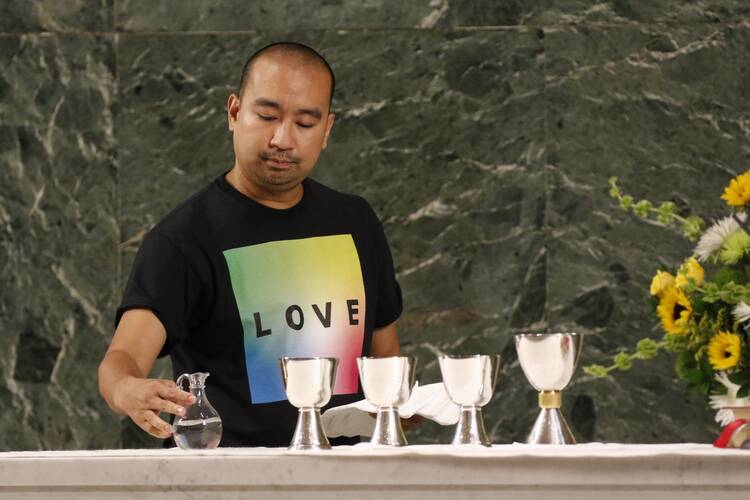 Altar server Angelo Alcasabas prepares the altar during an annual “Pre-Pride Festive Mass” welcoming L.G.B.T.Q. Catholics at St. Francis of Assisi Church in New York City on June 29, 2019. (CNS photo/Gregory A. Shemitz)