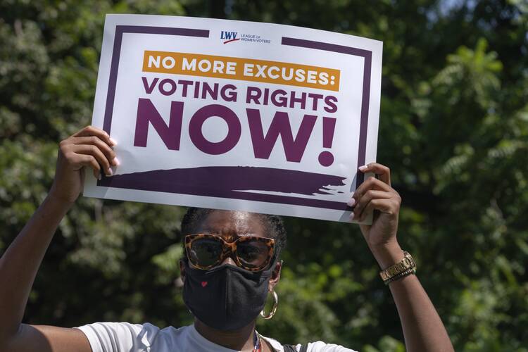 LaQuita Howard of Washington, with the League of Women Voters, attends a rally for voting rights, Tuesday, Aug. 24, 2021, near the White House in Washington. (AP Photo/Jacquelyn Martin)