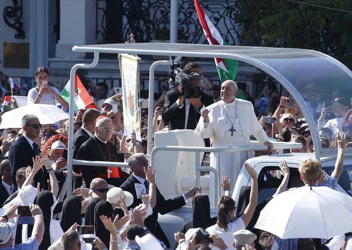 Pope Francis greets the crowd as he arrives to celebrate the closing Mass of the International Eucharistic Congress at Heroes' Square in Budapest, Hungary, Sept. 12, 2021. Also pictured in the popemobile is Cardinal Péter Erdo of Esztergom-Budapest. (CNS photo/Paul Haring)