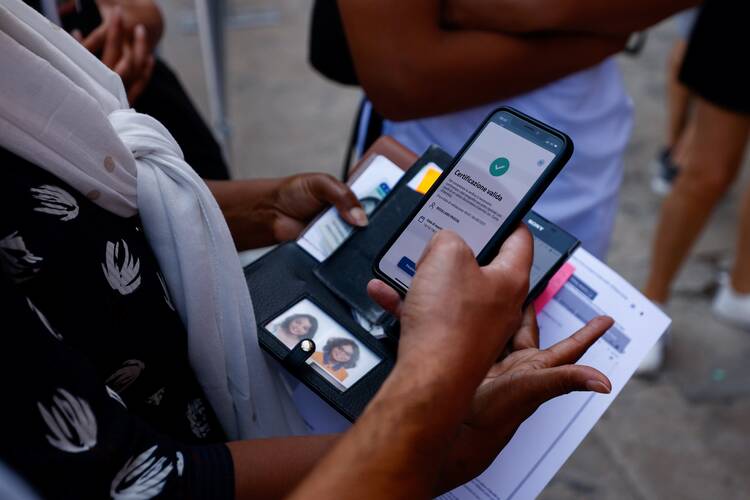 A woman has a green check mark on her phone's screen outside the Vatican Museums.