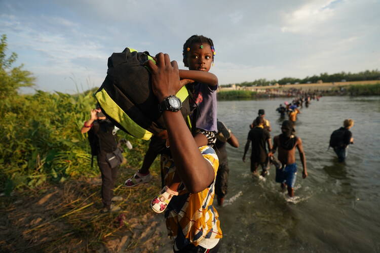 Migrants, many from Haiti, cross the Rio Grande from Del Rio, Texas, to return to Ciudad Acuna, Mexico, Tuesday, Sept. 21, 2021, to avoid deportation from the U.S. The U.S. is flying Haitians camped in a Texas border town back to their homeland and blocking others from crossing the border from Mexico. (AP Photo/Fernando Llano)