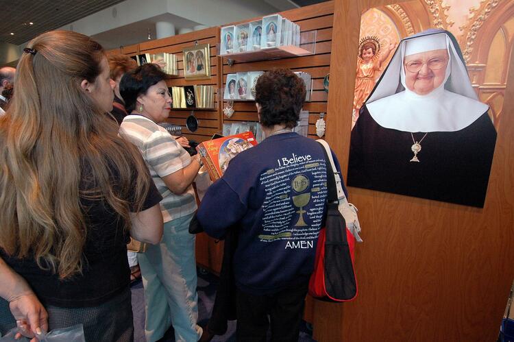 Attendees examine a poster of Mother Angelica.