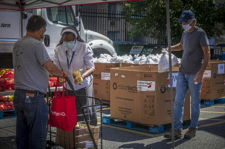 Sister Romana Uzodimma, a Sister of the Handmaids of the Holy Child Jesus, distributes food at Catholic Charities' Spanish Catholic Center in Washington on July 15, 2020. (CNS photo/Chaz Muth)