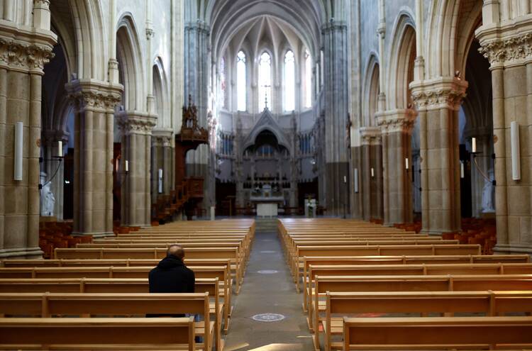 A man prays in the nearly-empty St. Martin’s Church near Nantes, France, on Oct. 5, 2021.