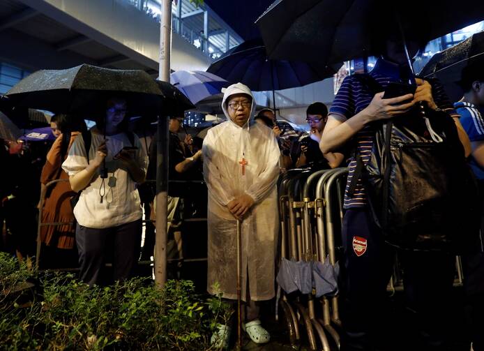 People pray during a Catholic service outside the Legislative Council building in Hong Kong as they protest the extradition bill with China June 11, 2019. (CNS photo/Thomas Peter, Reuters)