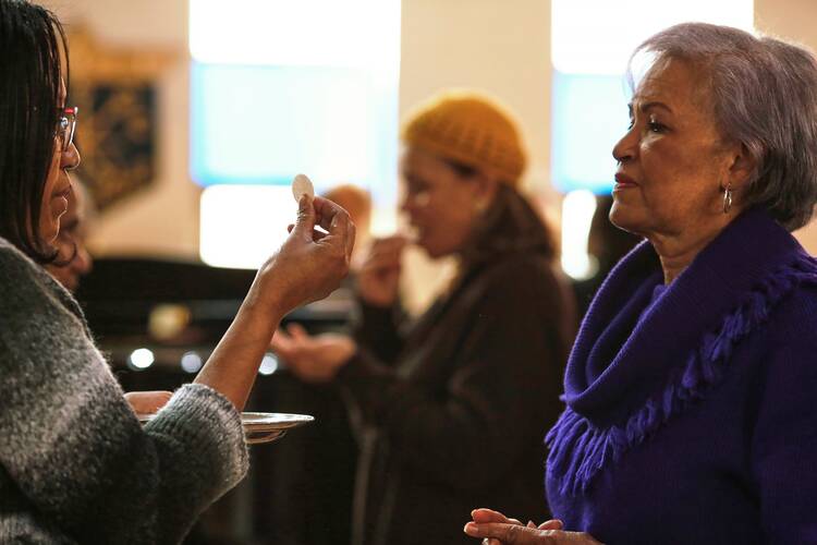 A woman presents herself for Communion during a March 8, 2020, Mass at Our Lady of Lourdes Catholic Church in Atlanta. (CNS photo/Christopher Aluka Berry, Reuters)