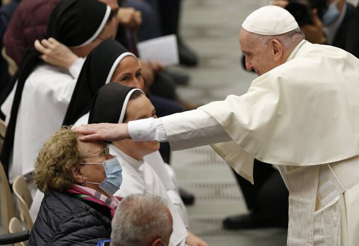 Pope Francis greets a woman during his general audience in the Paul VI hall at the Vatican Nov. 10, 2021.