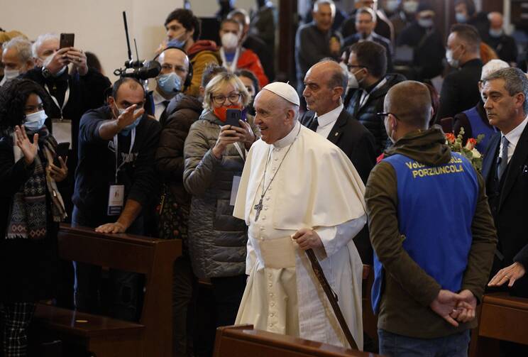 Pope Francis carries a pilgrim's staff as he arrives for a meeting with the poor at the Basilica of St. Mary of the Angels in Assisi, Italy, on Nov. 12, 2021. The visit was in preparation for the celebration of the World Day of the Poor. (CNS photo/Paul Haring)