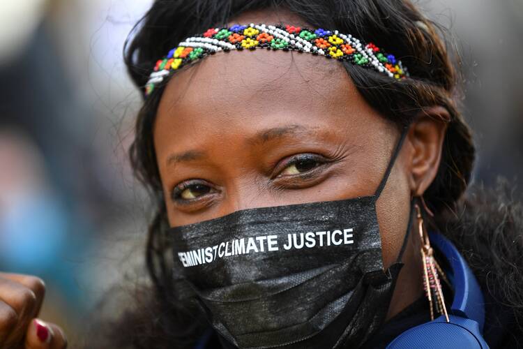 An activist wearing a protective mask takes part in a protest outside the U.N. Climate Change Conference in Glasgow, Scotland, Nov. 12, 2021. (CNS photo/Dylan Martinez, Reuters)