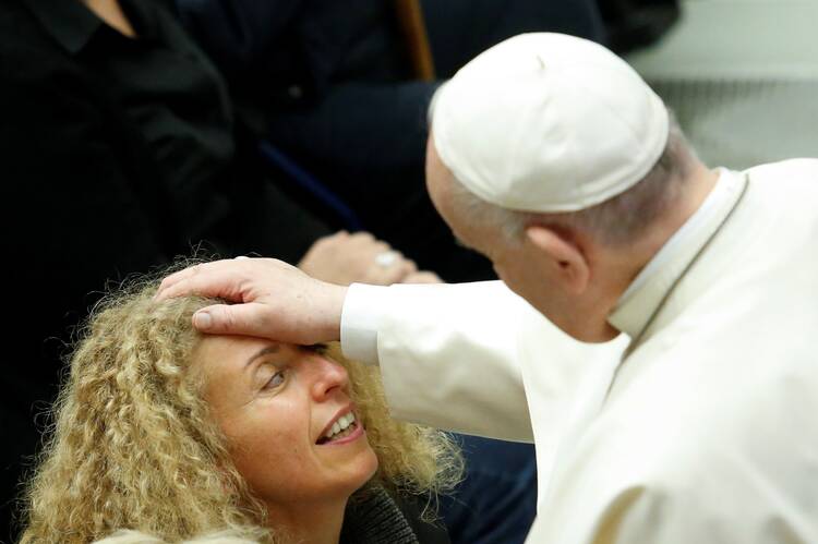 Pope Francis blesses a woman during his weekly general audience in the Paul VI hall at the Vatican.