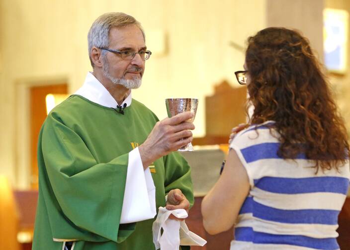 Deacon Michael Boldizar hands the chalice to a communicant during Mass July 21, 2019, at St. Anne Church in Garden City, N.Y. (CNS photo/Gregory A. Shemitz)