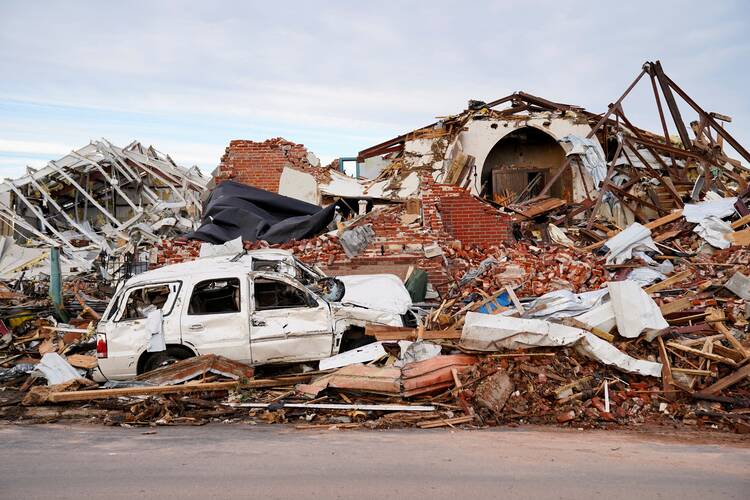 Debris, including a wrecked SUV, surrounds a destroyed home in Mayfield, Ky., Dec. 11, 2021, after a devastating tornado ripped through the town.