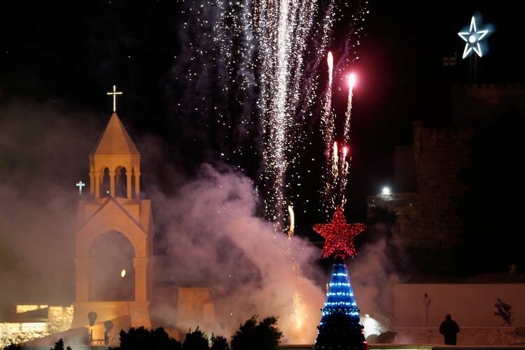 Fireworks illuminate the Church of the Nativity as Palestinians light a Christmas tree at Manger Square in Bethlehem, West Bank, Dec. 4, 2021. (CNS photo/Mussa Qawasma, Reuters)