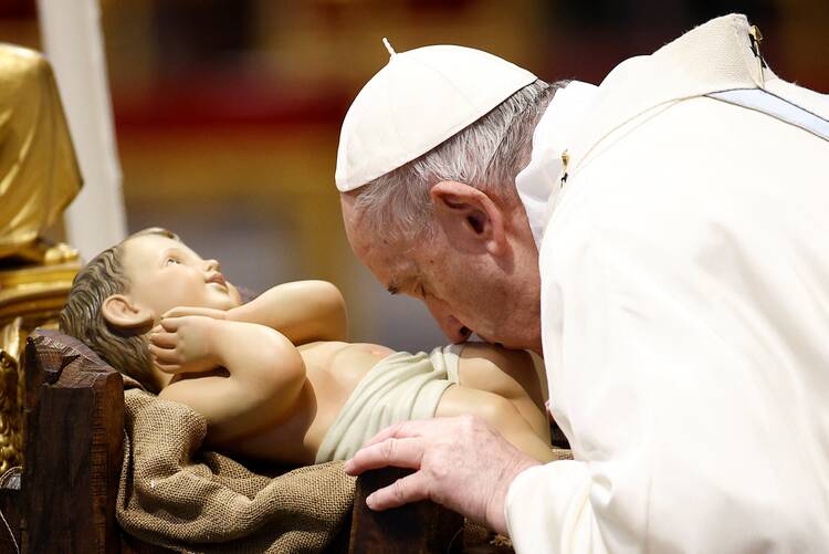 Pope Francis venerates a figurine of the baby Jesus at the beginning of Mass for the feast of Mary, Mother of God, in St. Peter's Basilica at the Vatican Jan. 1, 2022. (CNS photo/Guglielmo Mangiapane, Reuters)