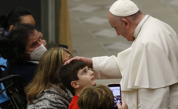 Pope Francis greets a boy during his general audience in the Paul VI hall at the Vatican Jan. 5, 2022.