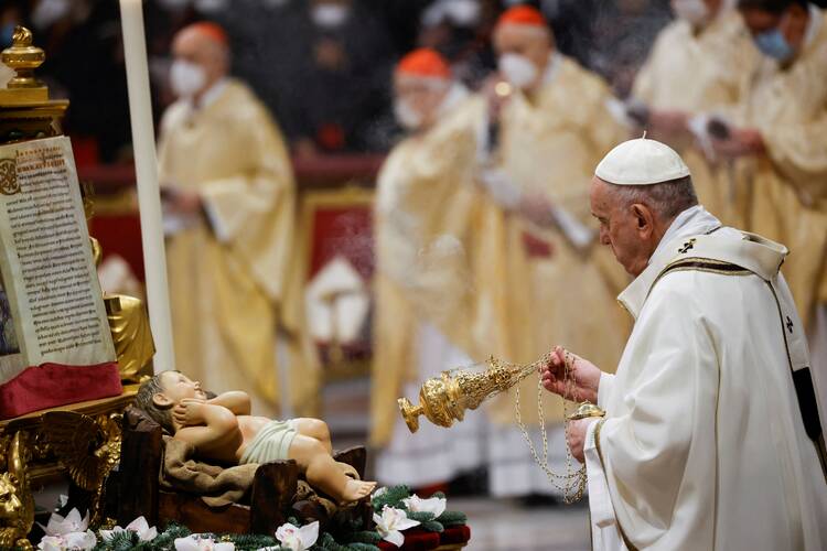 Pope Francis burns incense as he venerates a figurine of the baby Jesus during Mass for the feast of Epiphany in St. Peter's Basilica at the Vatican.