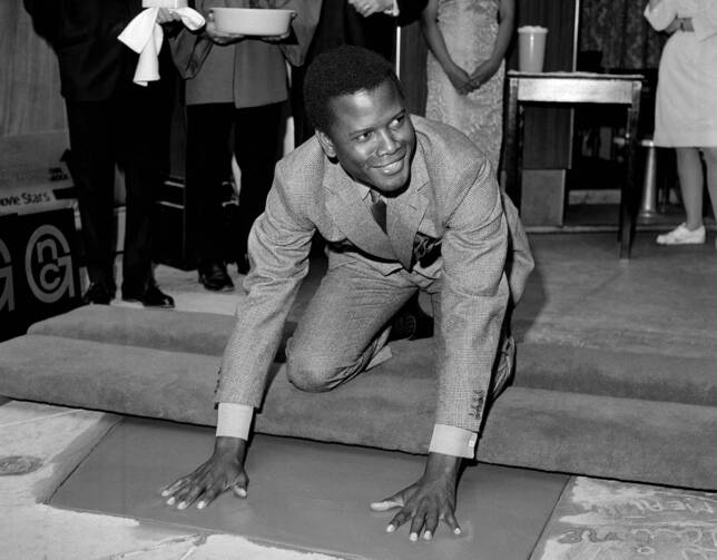 Sidney Poitier places his hands in wet cement at Grauman's Chinese Theater in Los Angeles on June 23, 1967. Poitier, the first Black actor to win an Academy Award for best lead performance, died on Jan. 6. He was 94. (AP Photo/File)