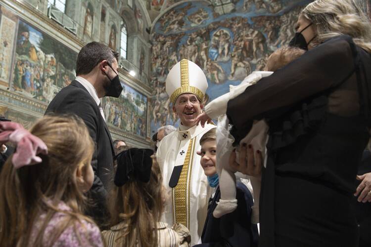 Pope Francis greets family members of a newly baptized baby after celebrating Mass marking the feast of the Baptism of the Lord in the Sistine Chapel at the Vatican on Jan. 9, 2022.