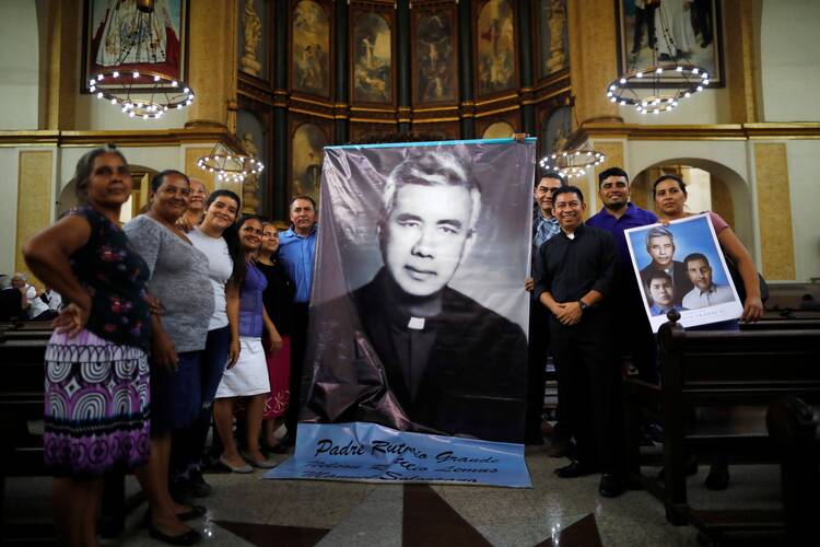 People pose with images of Rutilio Grande, S.J., following a Mass in his honor at a church in San Salvador, El Salvador, on Feb. 22, 2020. (CNS photo/Jose Cabezas, Reuters)