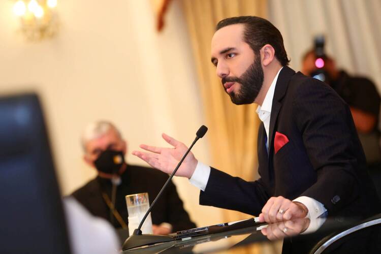 A prelate wearing a protective mask looks on as Salvadoran President Nayib Bukele takes part in a meeting at the Presidential House in San Salvador May 3, 2021. (CNS photo/Secretaria de Prensa de La Presidencia handout via Reuters)