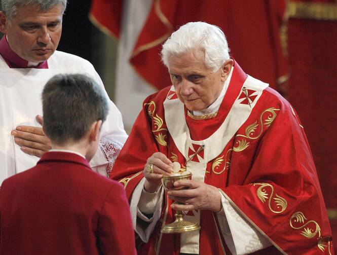 Pope Benedict XVI gives Communion to a young man during Mass at Westminster Cathedral in London.