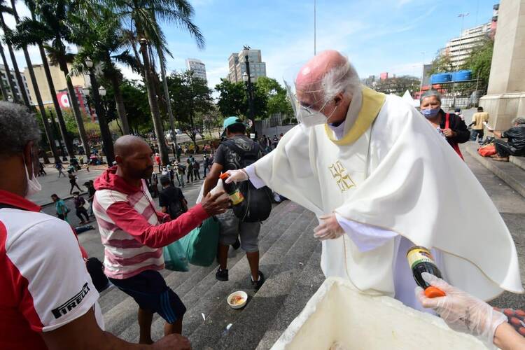 Father Lancellotti distributes food to homeless people in front of São Paulo’s metropolitan cathedral. Photo: Luciney Martins.