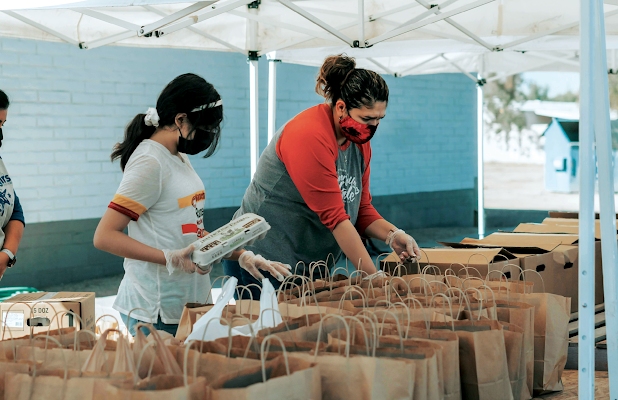 Volunteers at a food bank prepare groceries for distribution. (Photo by Ismael Paramo on Unsplash)