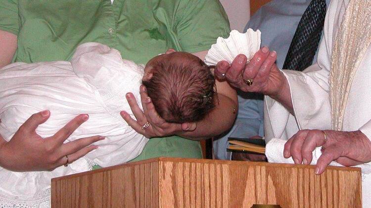 A baby is baptized in this 2007 file photo. Father Andres Arango, pastor of St. Gregory Parish in Phoenix, submitted his resignation letter to Phoenix Bishop Thomas J. Olmsted Feb. 1, 2022, for performing invalid baptisms throughout his ministry by regularly using an incorrect formula. (CNS photo/Lisa Schulte, Catholic Voice)