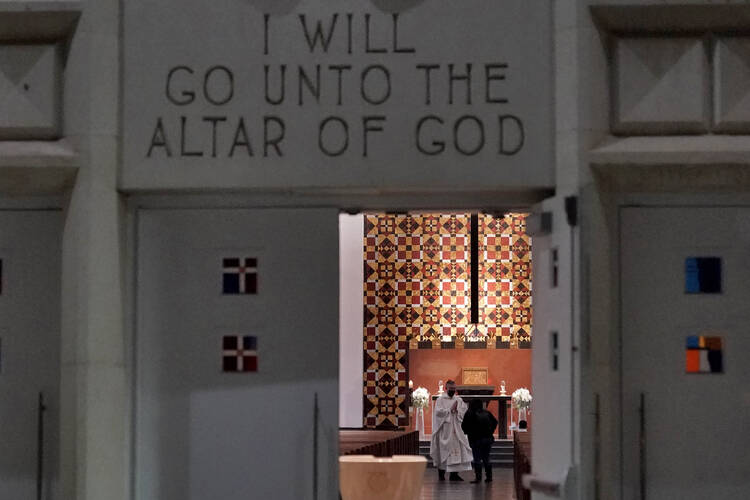 The Rev. Andrés Arango, speaks with a parishioner inside St. Gregory Catholic Church, Thursday, Feb. 24, 2022, in Phoenix after a baptism “do-over.”