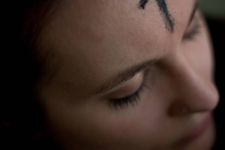 A woman with a cross of ashes on her forehead.