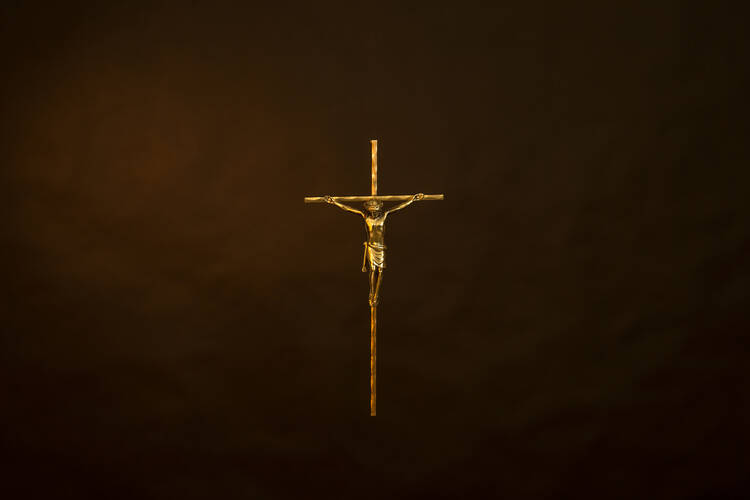 A thin golden crucifix over a black background.