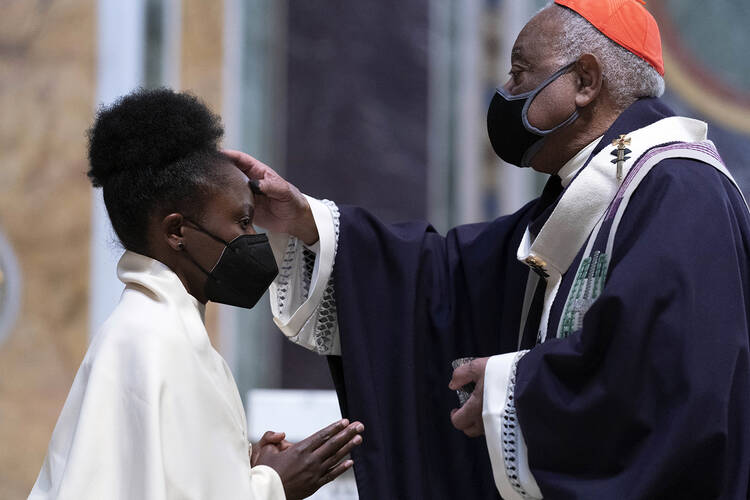 Cardinal Wilton Gregory, Archbishop of Washington, places ashes on the forehead of a parishioner during the Ash Wednesday Mass at Saint Matthew the Apostle Cathedral in Washington, Wednesday, March, 2, 2022.